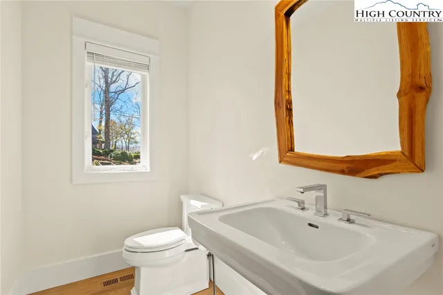 a bathroom with a sink and mirror with toilet