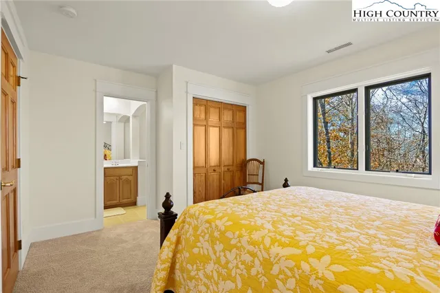 a bedroom with a bed and large windows