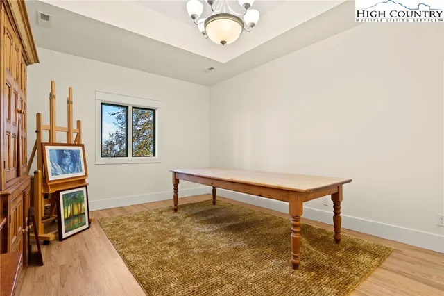 a view of a livingroom with wooden floor and furniture