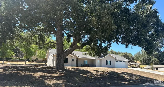 a front view of a house with a tree