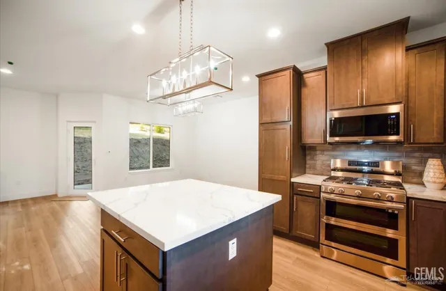a kitchen with stainless steel appliances a stove a microwave and a refrigerator