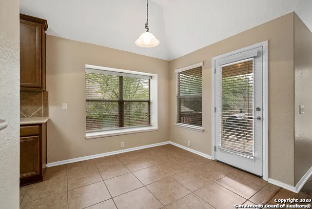 a view of an empty room with a window and fire place