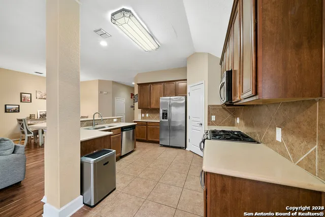a kitchen with stainless steel appliances granite countertop a stove a sink and a refrigerator