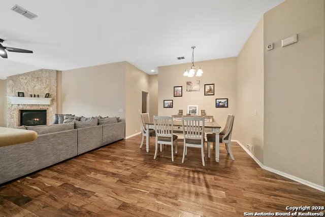 a dining room with furniture a fireplace and wooden floor