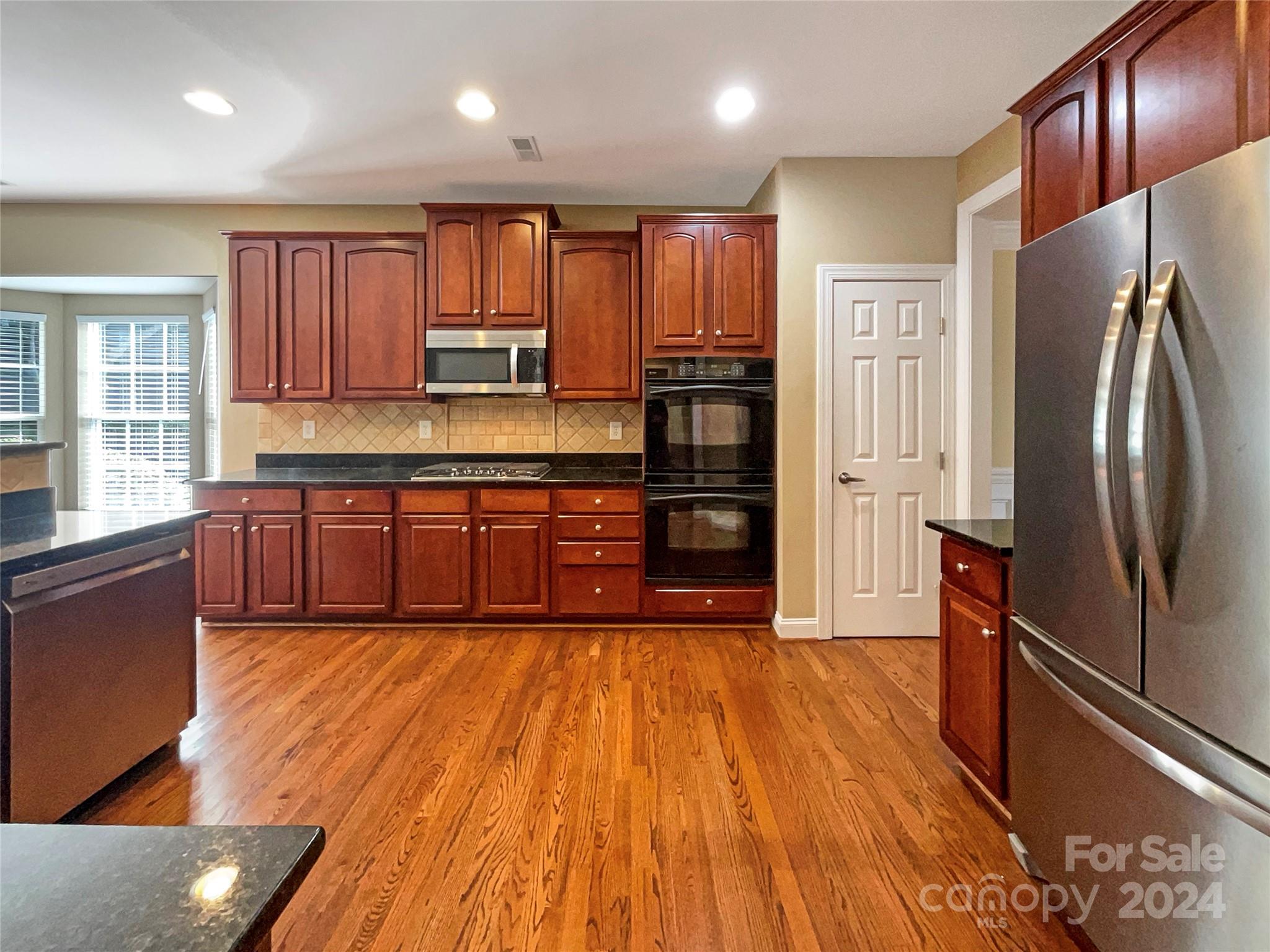 604 Panthers Way Fort Mill, SC 29708 - Photo 13 of 24 a large kitchen with wooden floors and wooden cabinets