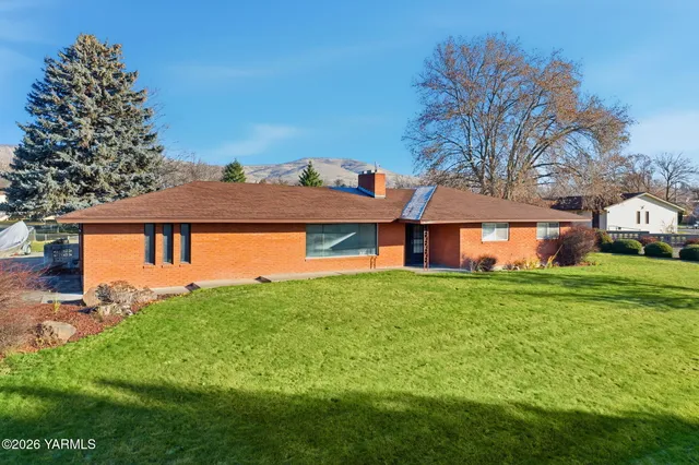 an aerial view of a swimming pool with outdoor seating and yard