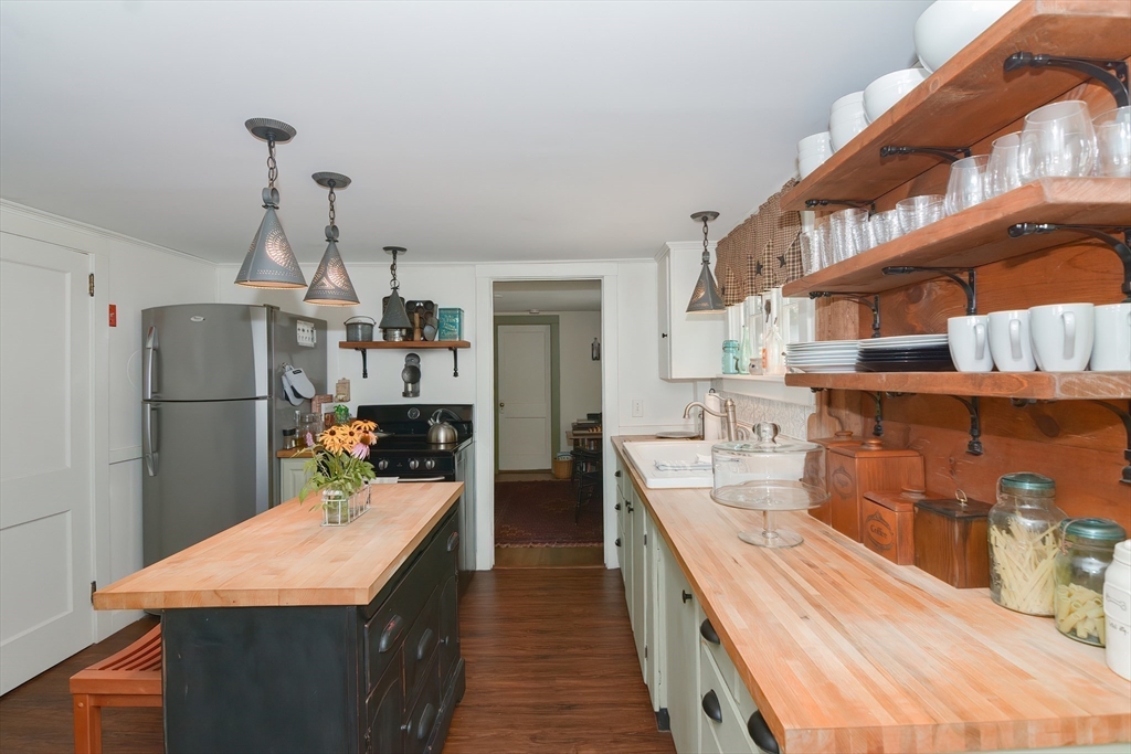 366 Breakneck Road Southbridge, MA 01550 - Photo 5 of 33 a kitchen with stainless steel appliances kitchen island granite countertop a refrigerator a sink dishwasher a stove and a dining table with wooden floor