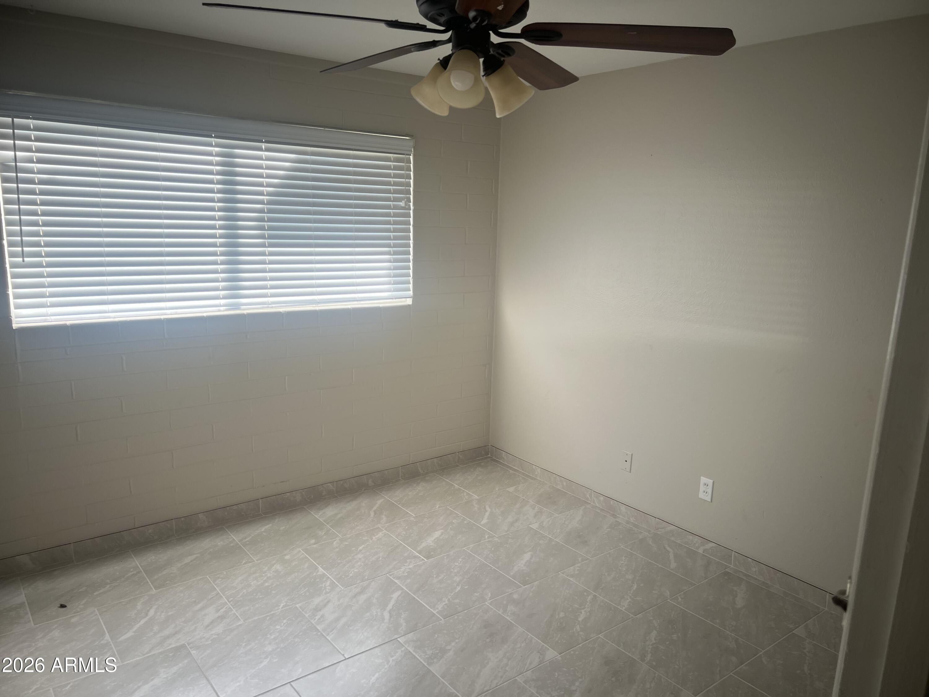 2420 West Butler Drive Phoenix, AZ 85021 - Photo 13 of 16 an empty room with a window and a fan
