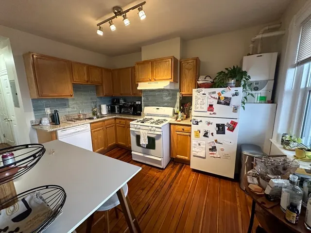 a kitchen with a white stove top oven and refrigerator