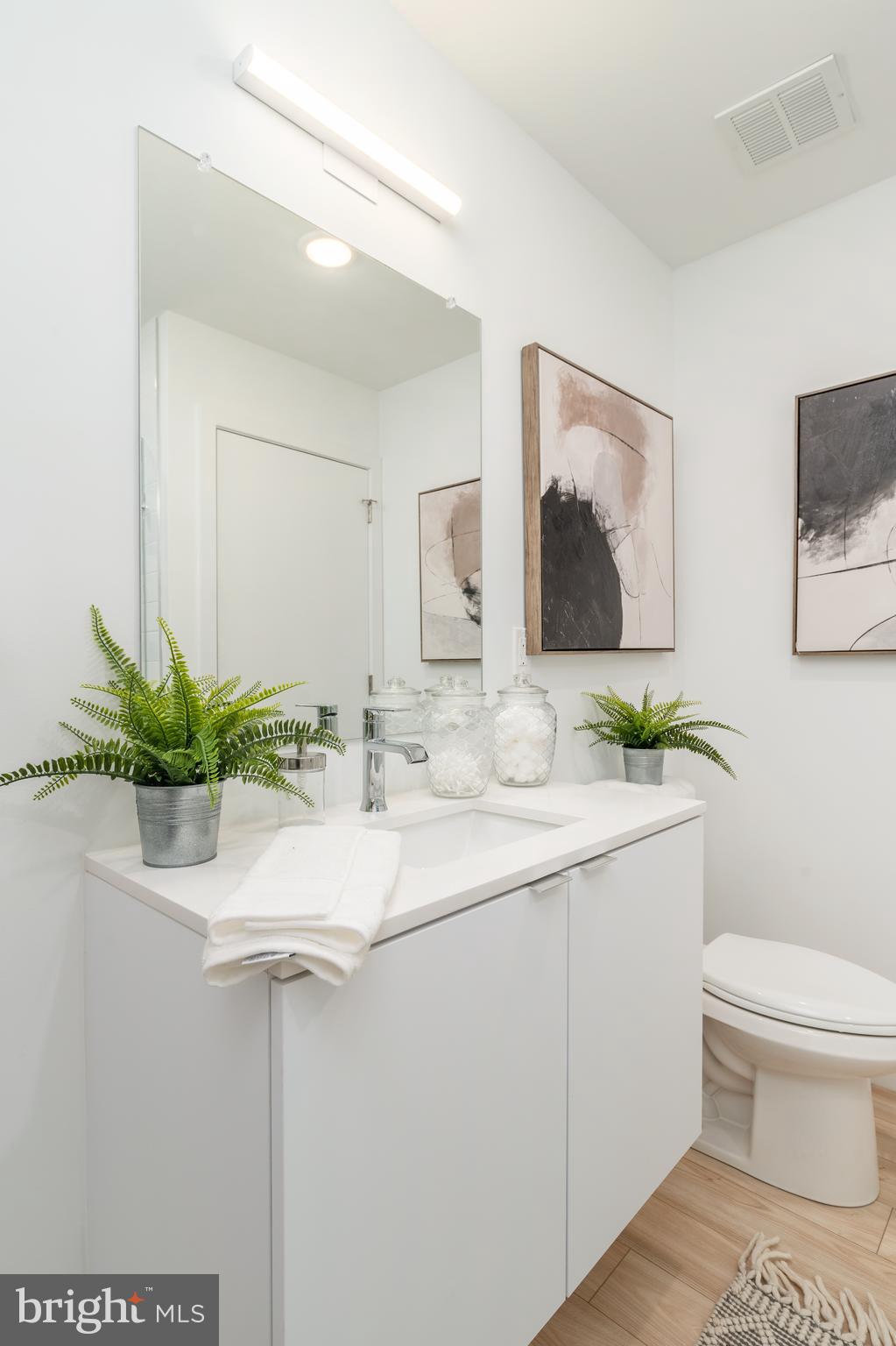 1131-39 North Front Street, Unit 503 Philadelphia, PA 19123 - Photo 31 of 44 a bathroom with a toilet a sink and mirror