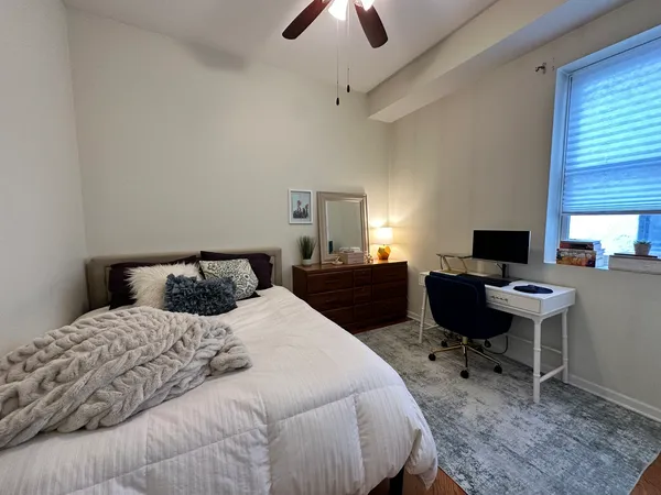 a bedroom with a bed and a computer on the desk