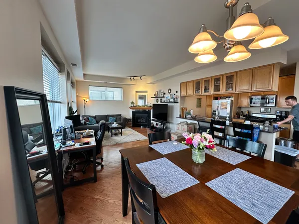 a living room with furniture kitchen view and a large window