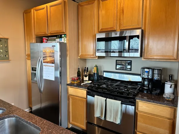 a kitchen with stainless steel appliances granite countertop a refrigerator and a stove