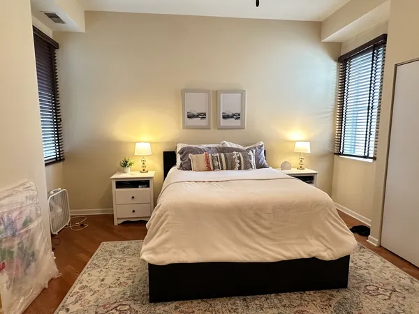 a bedroom with a bed and wooden floor