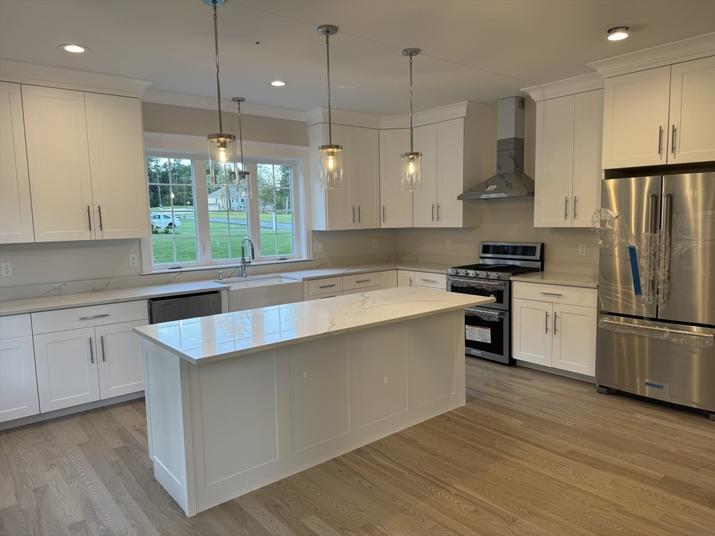 36 Meghan Circle Raynham, MA 02767 - Photo 5 of 37 a kitchen with stainless steel appliances granite countertop a sink a stove a refrigerator and island with wooden floor