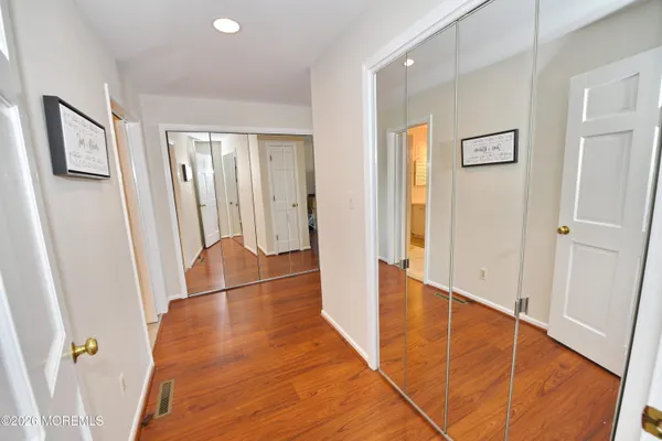 a view of a hallway with wooden floor and entryway