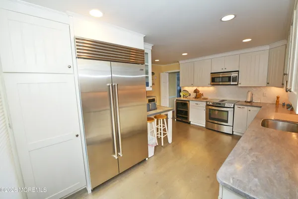 a kitchen with stainless steel appliances granite countertop a refrigerator and a stove