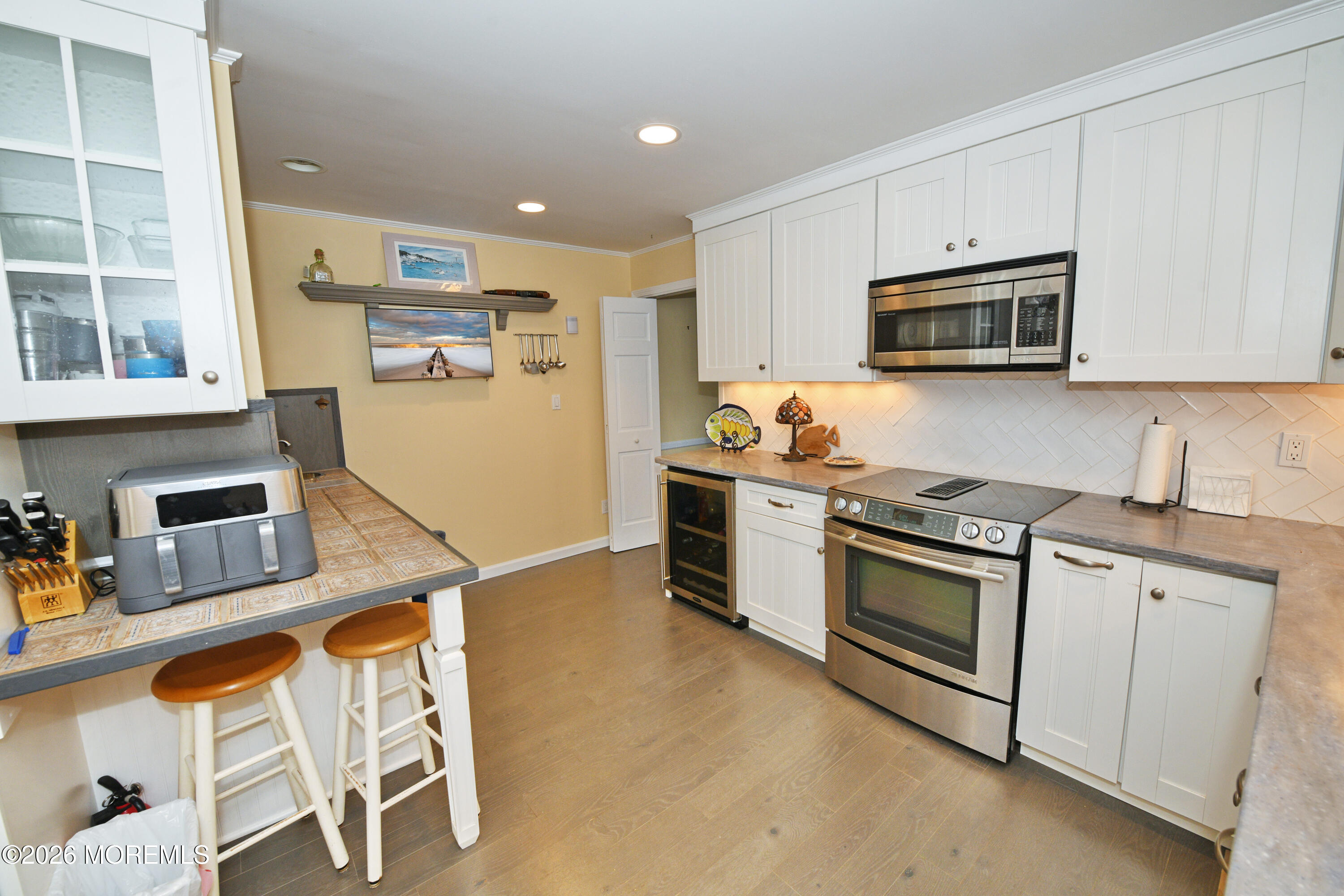 77 Bay Point Harbour Point Pleasant, NJ 08742 - Photo 8 of 39 a kitchen with stainless steel appliances granite countertop a stove top oven a sink dishwasher and white cabinets with wooden floor