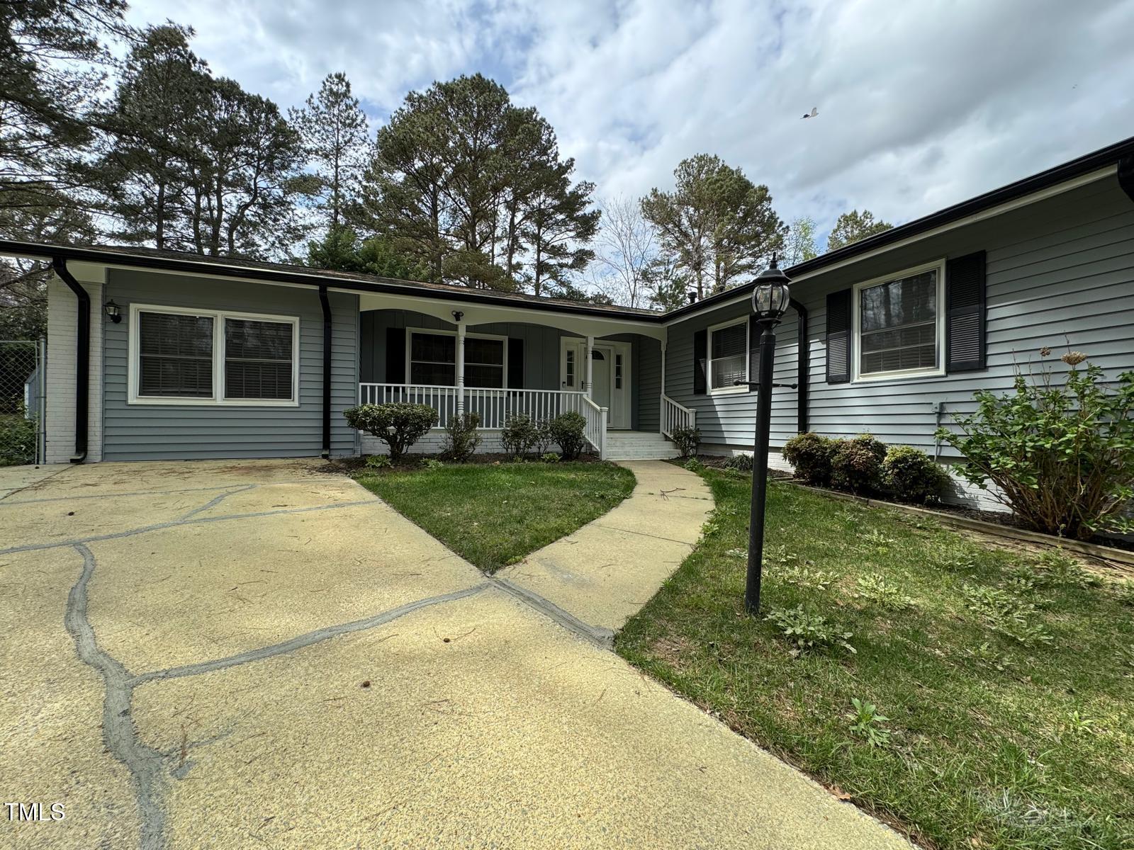 2616 Firelight Road Raleigh, NC 27610 - Photo 2 of 36 a view of a yard in front of a house with plants and large tree