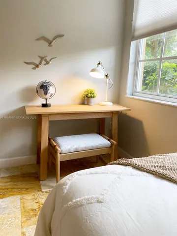 a bedroom with a bed and a lamp on the dresser