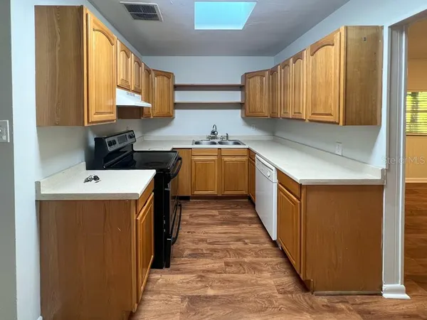 a kitchen with a sink a stove and cabinets
