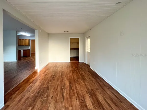a view of a big room with wooden floor and entryway