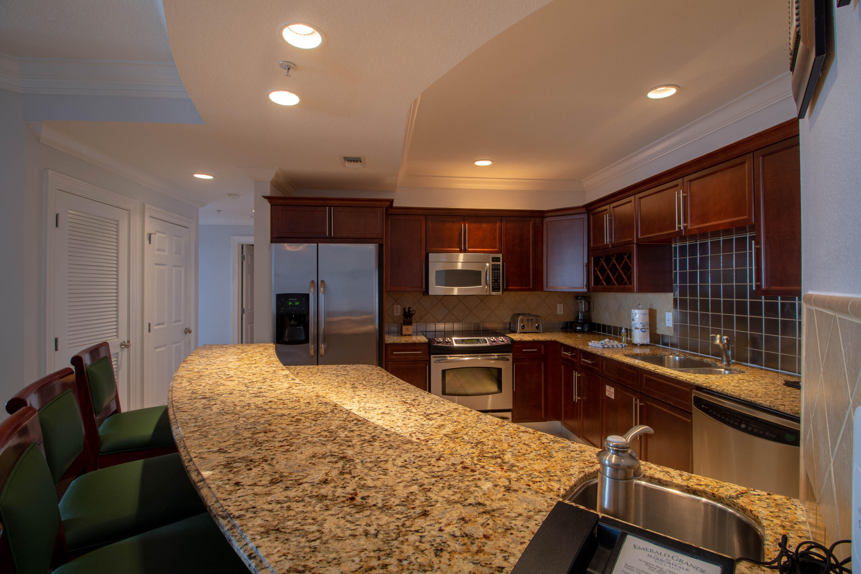 10 Harbor Boulevard, Unit E507F Destin, FL 32541 - Photo 7 of 28 a kitchen with stainless steel appliances granite countertop sink stove refrigerator and cabinets