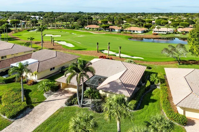 an aerial view of a house with a garden and lake view