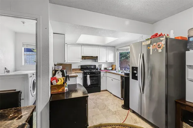 a kitchen with a refrigerator and a stove top oven