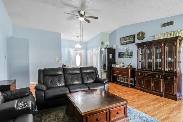 a living room with stainless steel appliances kitchen island granite countertop furniture a refrigerator a stove and a sink