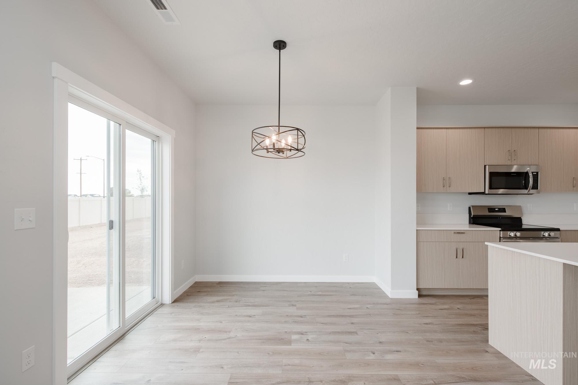 4155 North Delphi Avenue Meridian, ID 83646 - Photo 10 of 24 Kitchen featuring a chandelier, stainless steel appliances, light wood-style floors, recessed lighting, and pendant lighting
