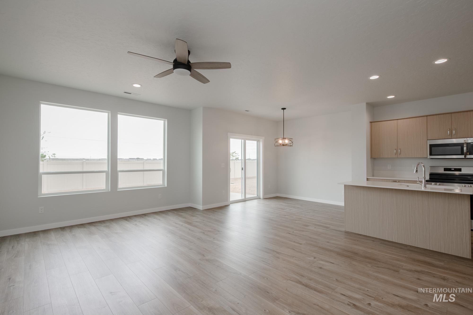 4155 North Delphi Avenue Meridian, ID 83646 - Photo 23 of 24 Kitchen featuring light brown cabinetry, open floor plan, appliances with stainless steel finishes, light wood-style flooring, and recessed lighting