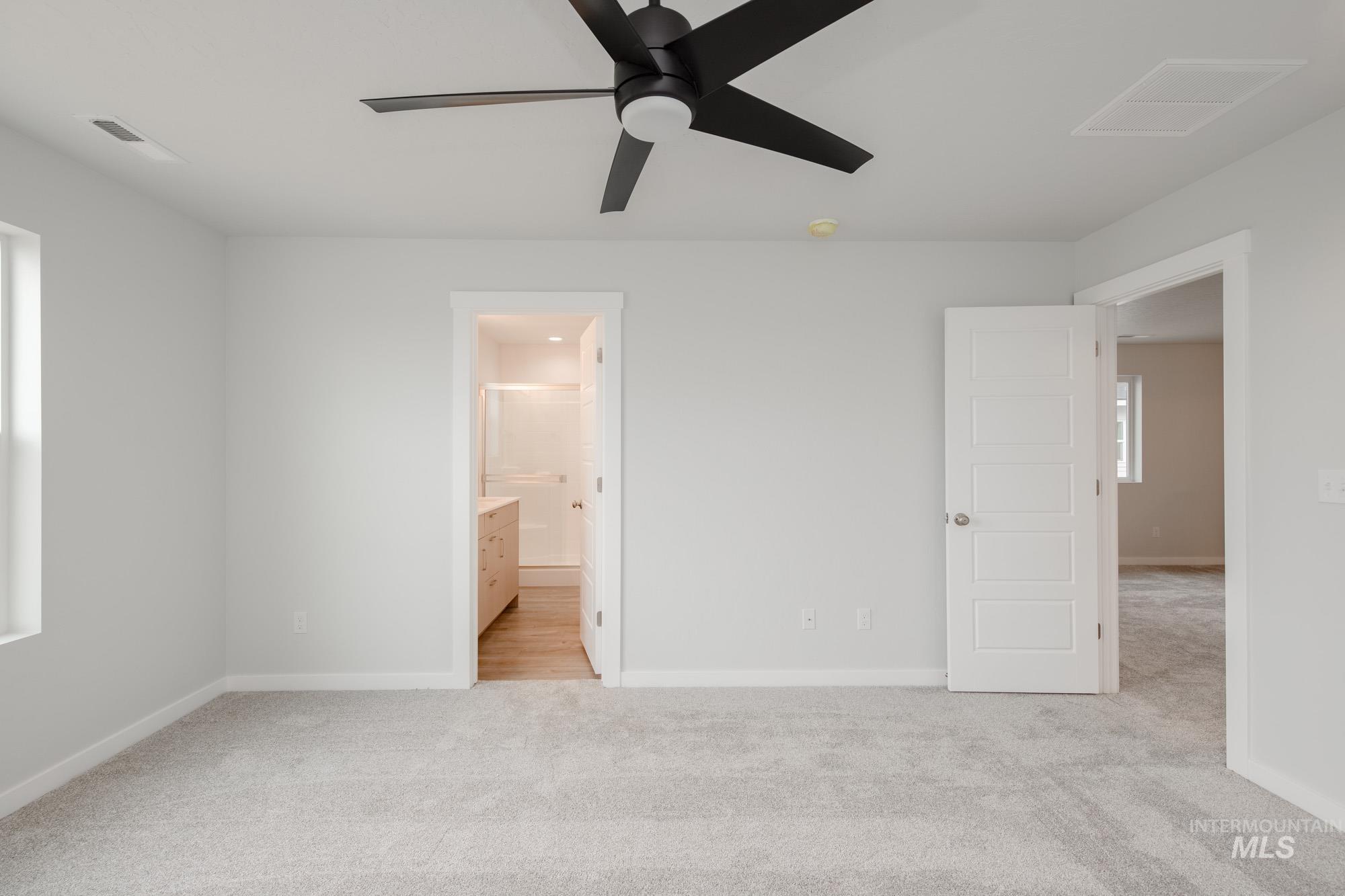 4155 North Delphi Avenue Meridian, ID 83646 - Photo 14 of 24 Unfurnished bedroom with light carpet, ensuite bathroom, and ceiling fan