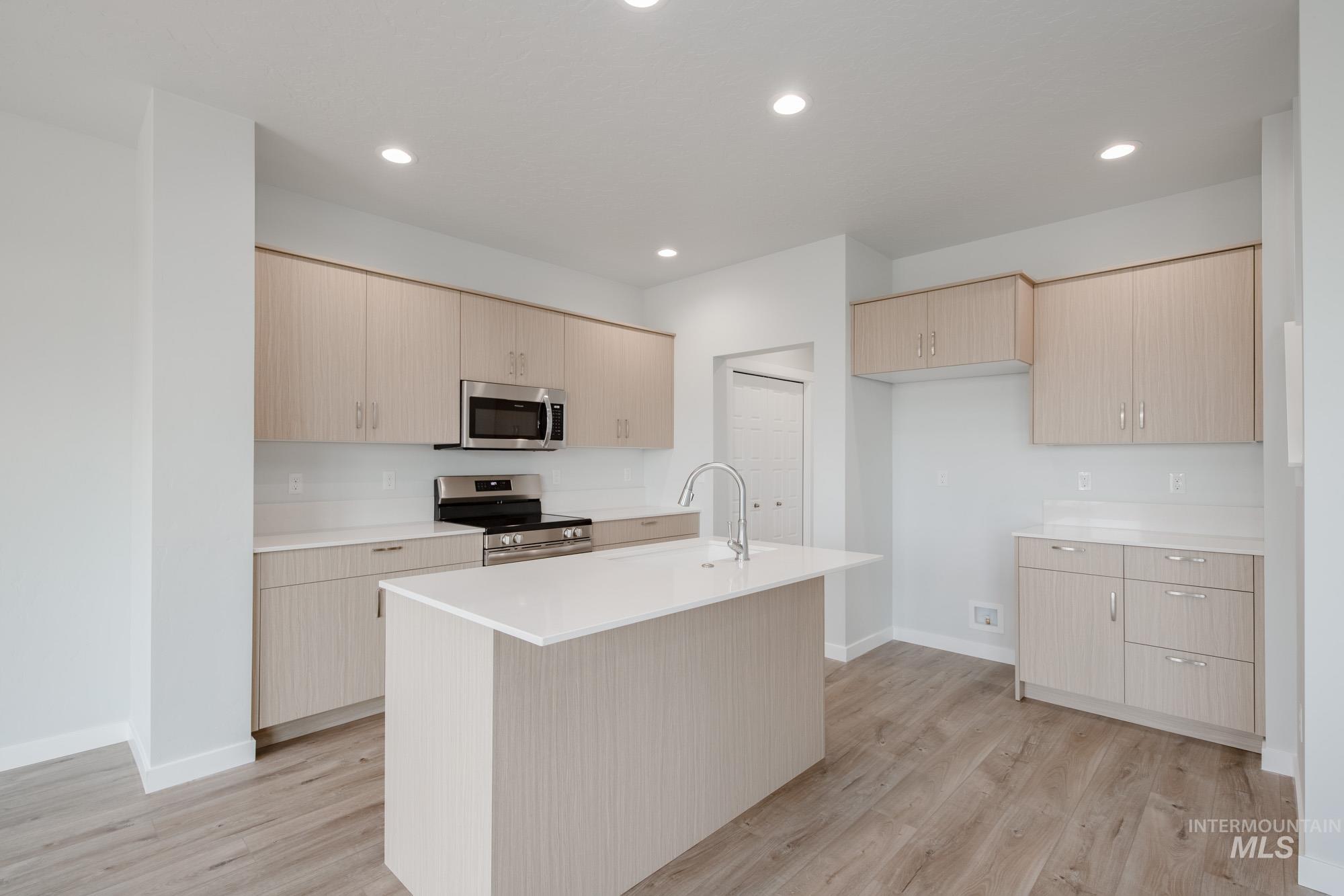 4155 North Delphi Avenue Meridian, ID 83646 - Photo 5 of 24 Kitchen with appliances with stainless steel finishes, light brown cabinetry, light wood finished floors, and recessed lighting