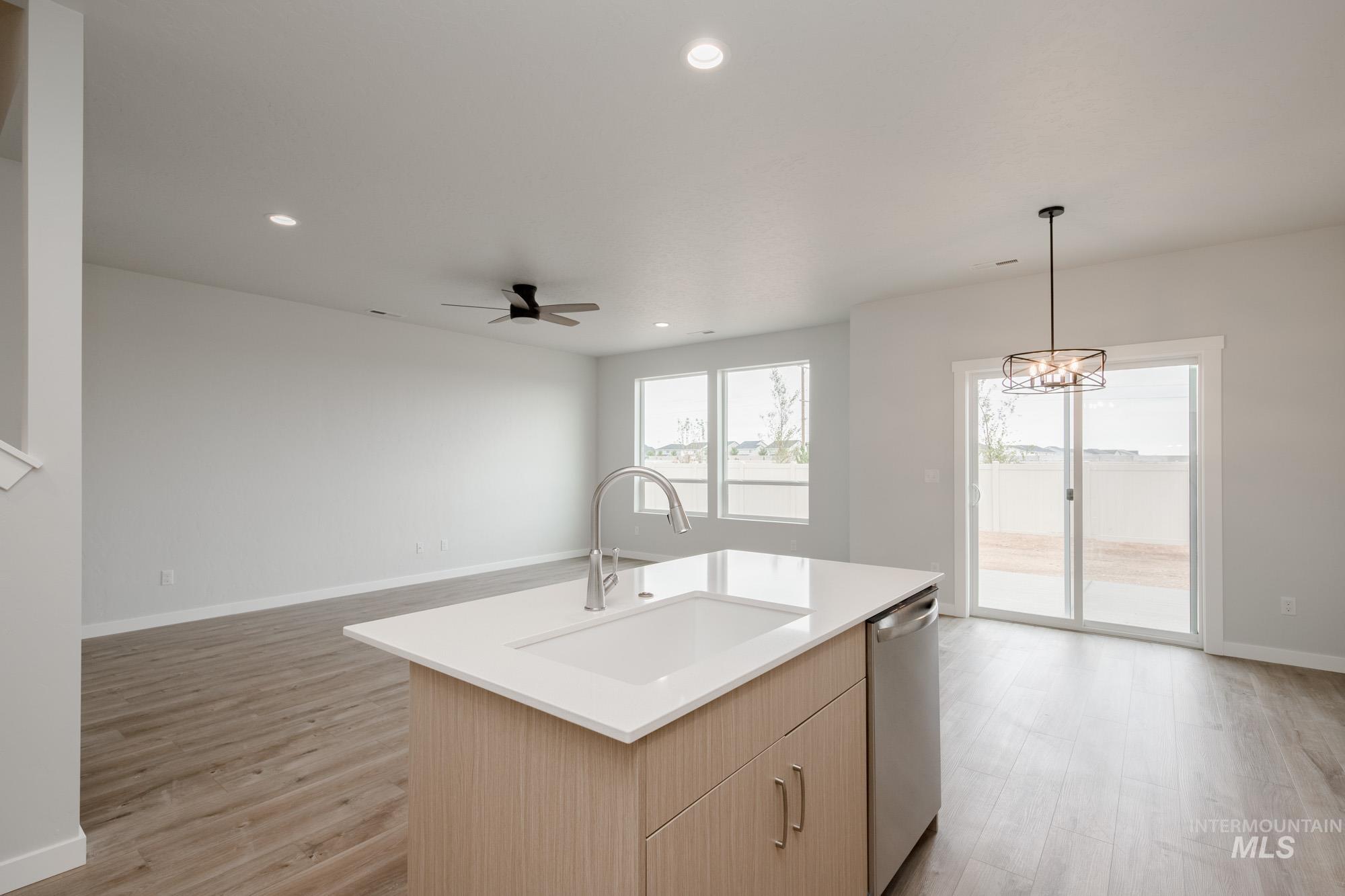 4155 North Delphi Avenue Meridian, ID 83646 - Photo 22 of 24 Kitchen featuring light brown cabinetry, recessed lighting, decorative light fixtures, open floor plan, and stainless steel dishwasher