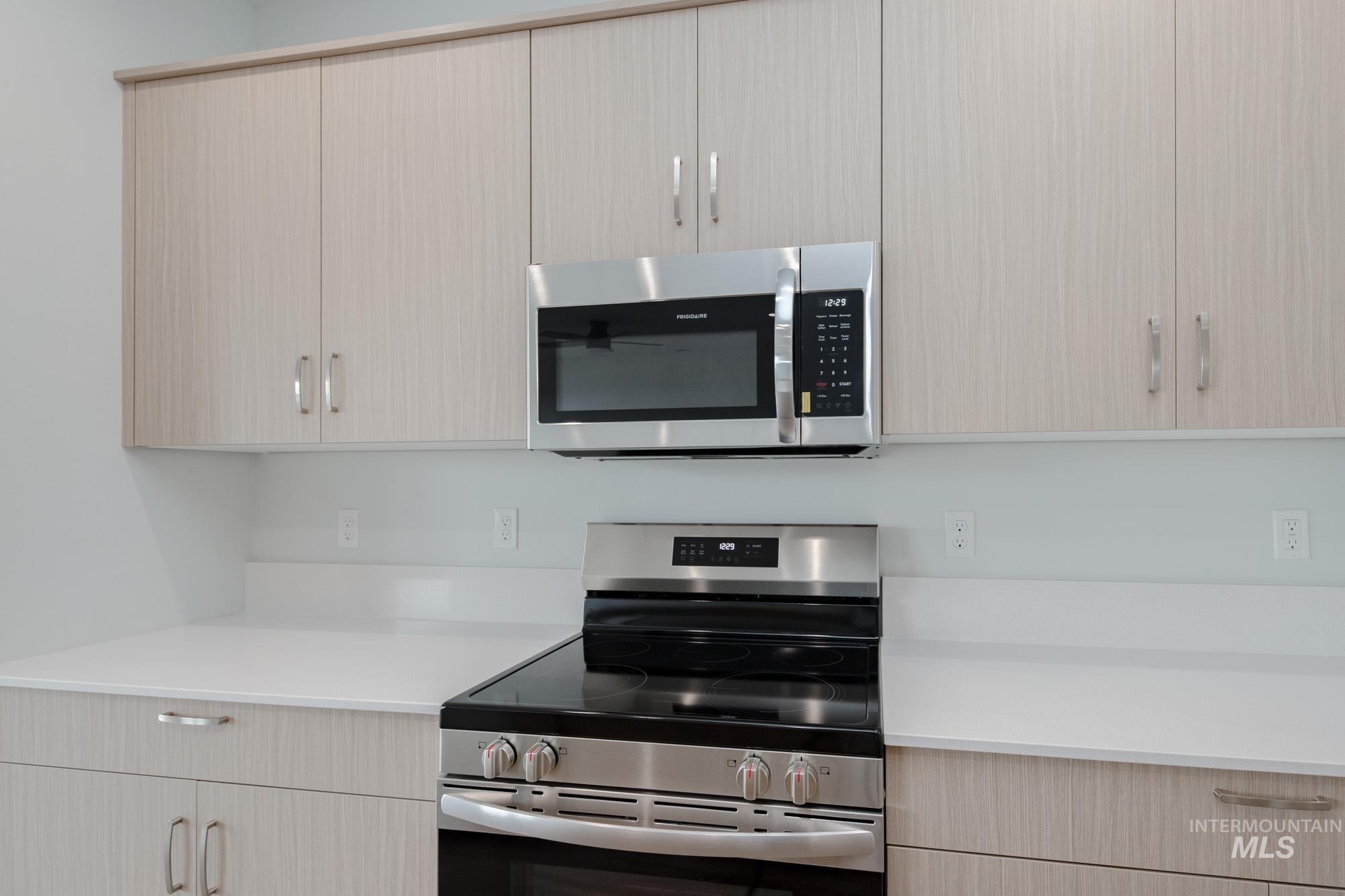 4155 North Delphi Avenue Meridian, ID 83646 - Photo 8 of 24 Kitchen with stainless steel appliances, light brown cabinetry, modern cabinets, and light stone counters