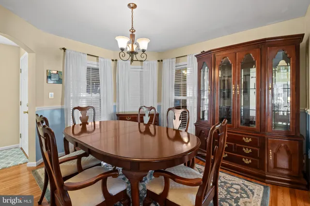 a dining room with furniture a chandelier and wooden floor