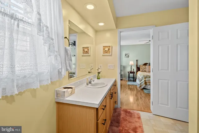 a bathroom with a granite countertop sink a mirror a shower and a bathtub