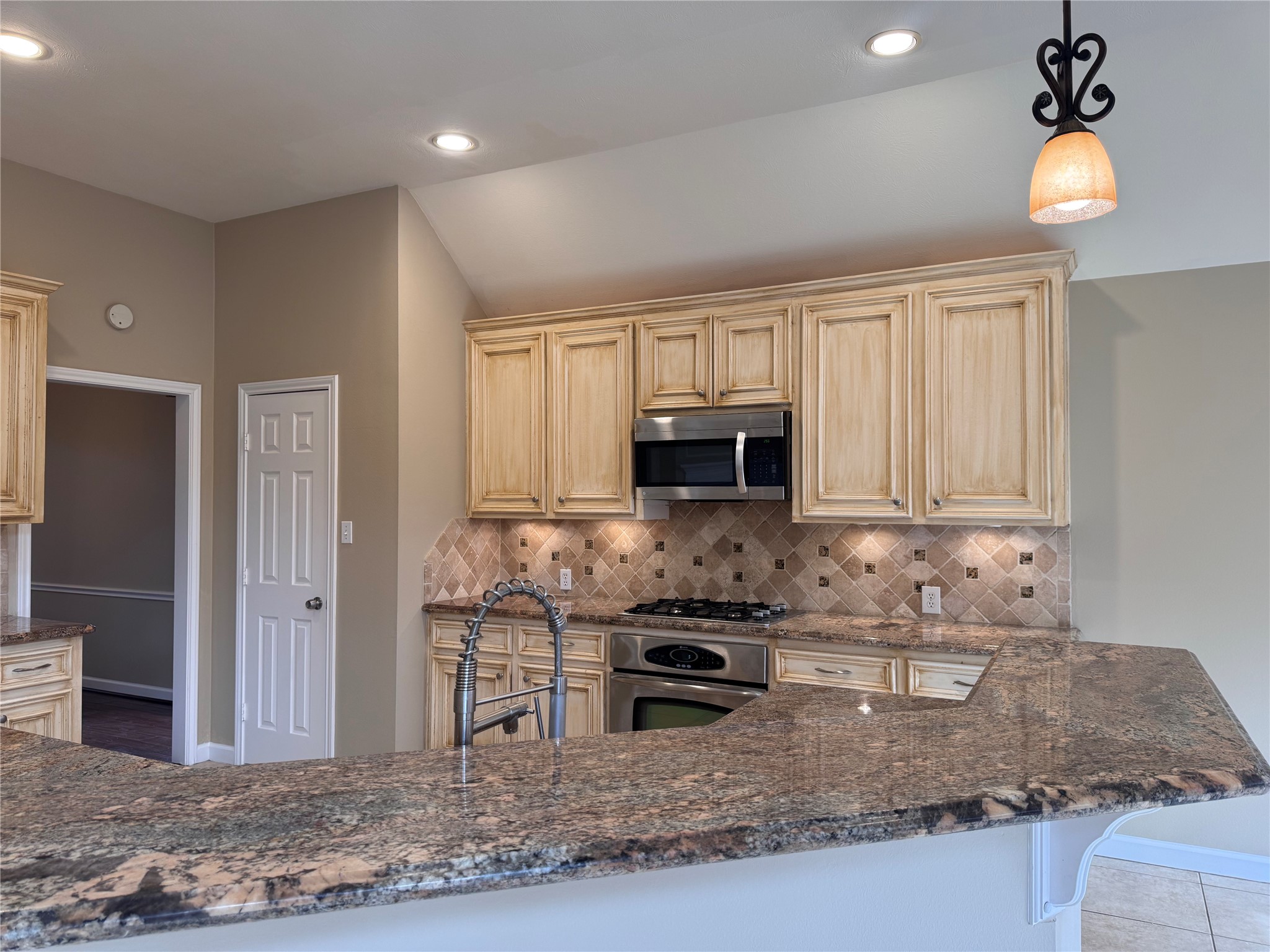 17243 Rush Trace Court Houston, TX 77095 - Photo 12 of 49 a kitchen with stainless steel appliances granite countertop a stove a sink and a microwave