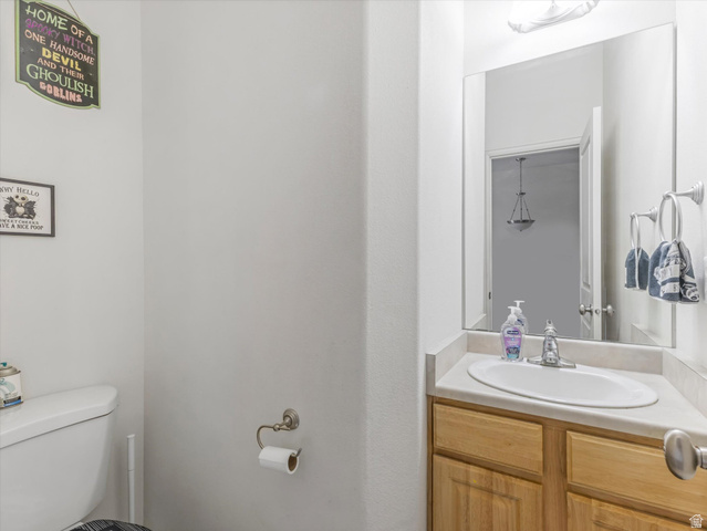 5038 West Red Shale Road Herriman, UT 84096 - Photo 9 of 16 Corner vanity with wood-finish cabinetry, a built-in sink, and a light-toned countertop