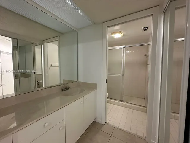 a bathroom with a granite countertop sink and shower