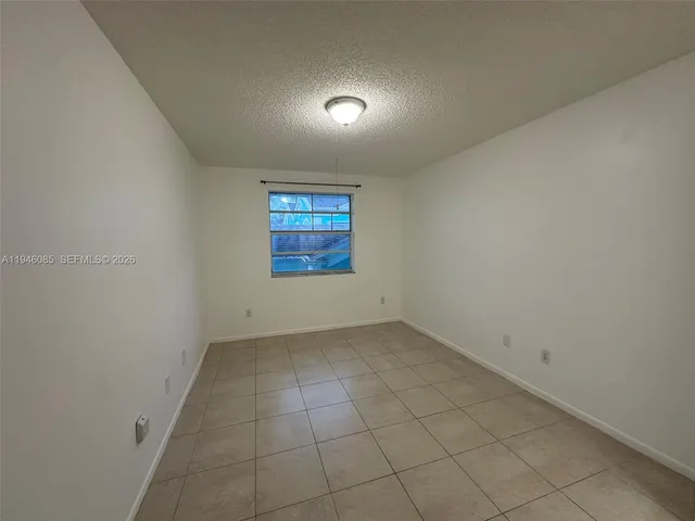 an empty room with a bench and a window