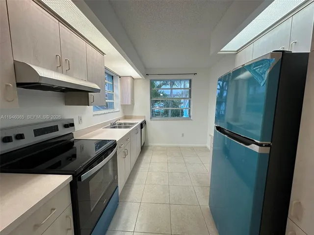 a kitchen with a stove a refrigerator and a sink