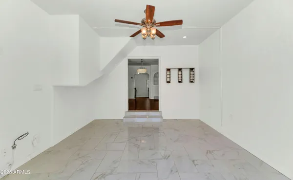 a view of a livingroom with a ceiling fan and a chandelier fan