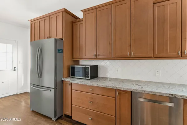 a kitchen with stainless steel appliances granite countertop a refrigerator a stove and a cabinets