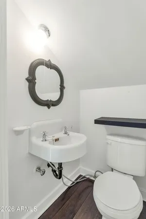 a bathroom with a toilet a sink and mirror