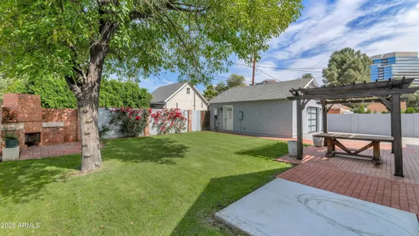 a view of a chair and table in backyard of the house