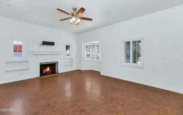 a view of a livingroom with a fireplace a ceiling fan and a fireplace