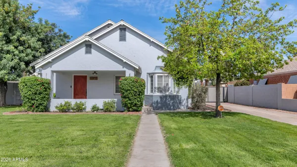 a front view of a house with a yard and trees