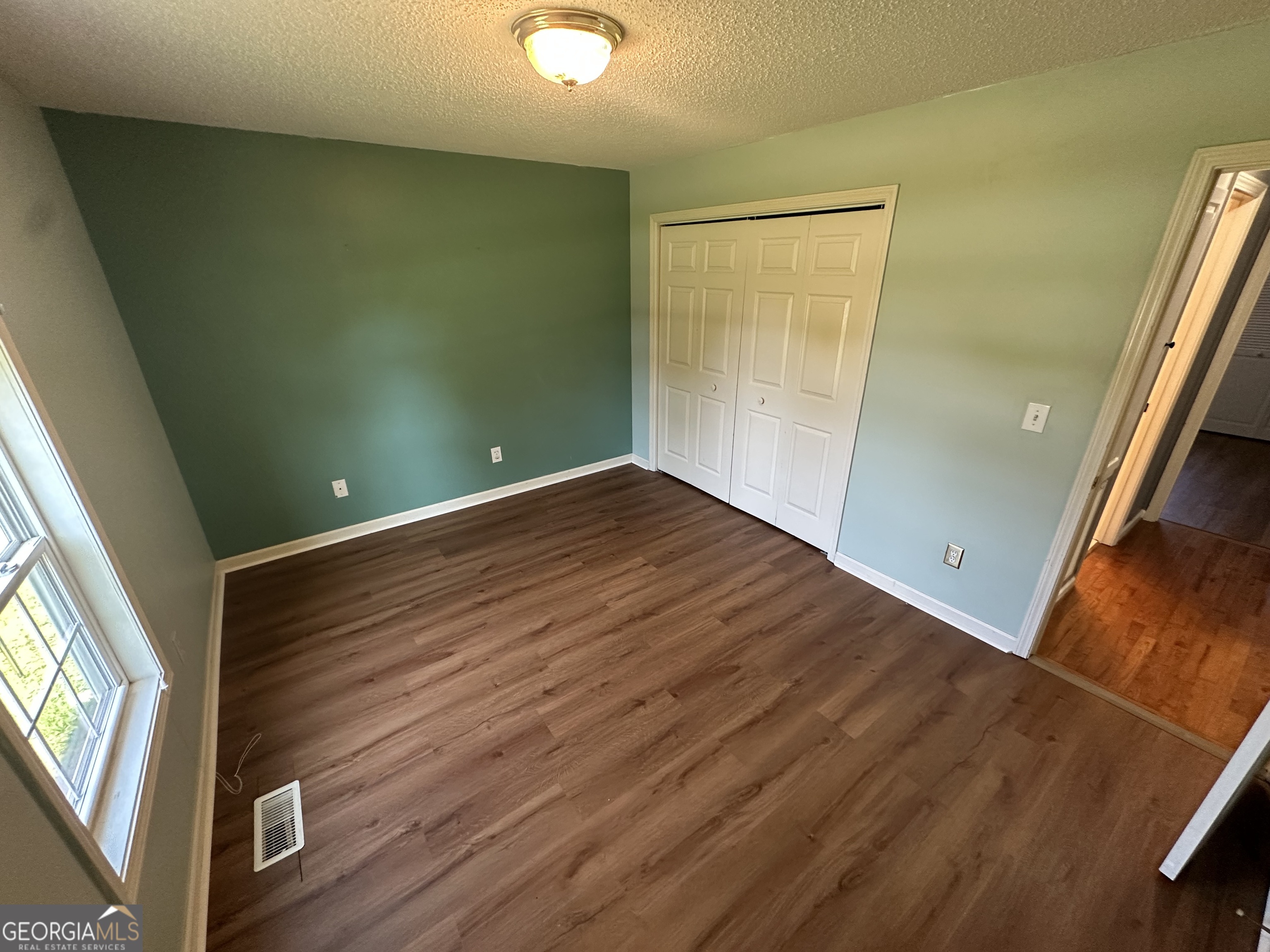 384 Sam Brown Boulevard Commerce, GA 30529 - Photo 6 of 25 a view of empty room with window and wooden floor